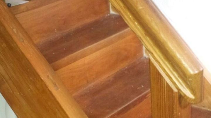 Eine Holztreppe wird gerade gepflegt, um ihr Aussehen zu verbessern und sie zu sch&uuml;tzen; der Kontext zeigt eine Wohnumgebung.