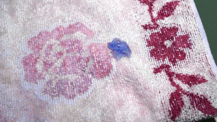 Ein handtuchartiges Objekt mit buntem Blumenmuster liegt auf einer Oberfl&auml;che, wahrscheinlich in einem Wohnraum oder Badezimmer.