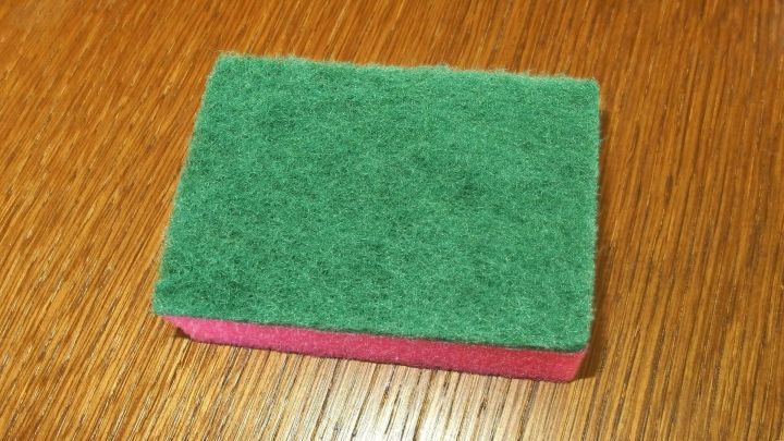 Ein Scheuerschwamm liegt auf einem Holzuntergrund. Er wird zum Entfernen von Hornhaut an F&uuml;&szlig;en verwendet.