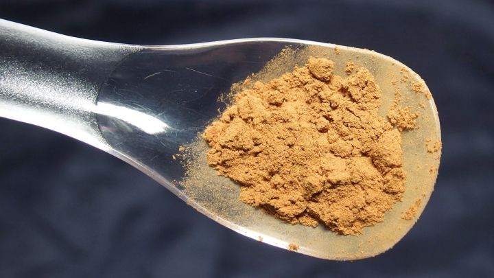 Ein L&ouml;ffel mit braunem Pulver liegt auf einem dunklen Stoff, m&ouml;glicherweise als Hinweis auf Ger&uuml;che im Staubsauger.