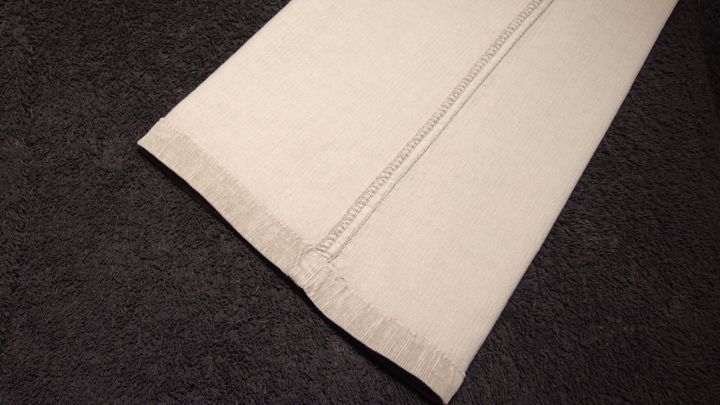 Ein Hosenbein mit klaren B&uuml;gelfalten liegt auf einem dunklen Hintergrund und zeigt die scharfen Materialien und N&auml;hte.