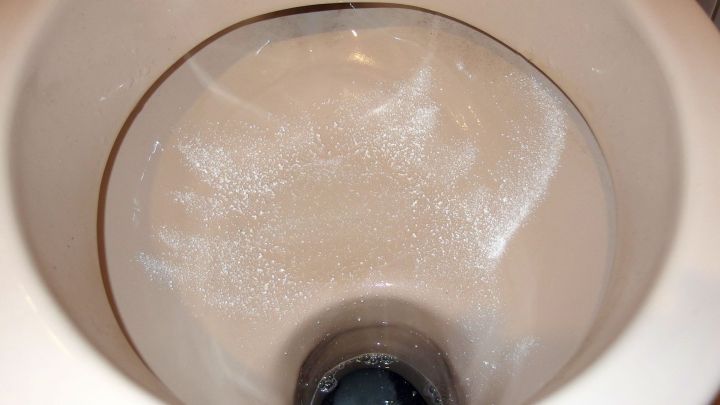 Eine Toilette mit Sp&uuml;lmaschinenpulver, das im Wasser aufsch&auml;umt, befindet sich in einem Badezimmer.