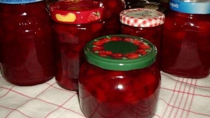 Gl&auml;ser mit Rhabarber-Erdbeer-Bananenmus stehen auf einem Tisch, umgeben von einem K&uuml;chenhandtuch.