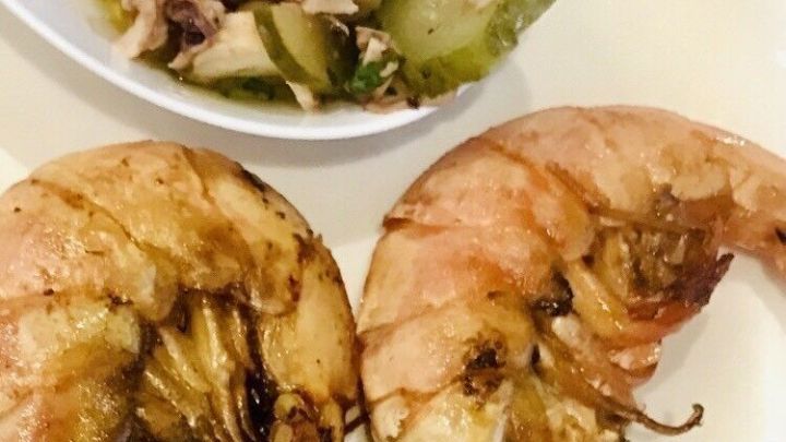 Gebratene Garnelen liegen auf einem Teller, umgeben von einer Beilage, goldbraun und appetitlich angerichtet.