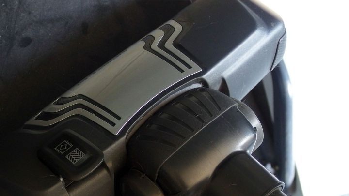 Der Staubsauger liegt bereit und wird angewendet, um Staub zu entfernen, w&auml;hrend ein dunkler Untergrund sichtbar ist.