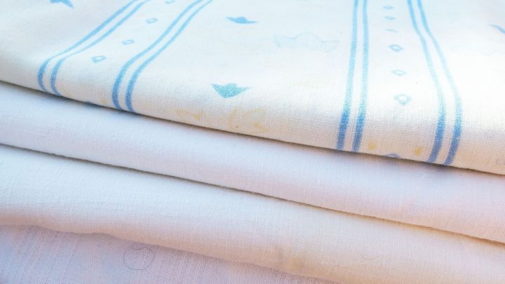 Gestapelte, fast b&uuml;gelfreie W&auml;sche liegt ordentlich auf einem Tisch, bereit zum Falten und Verstauen.