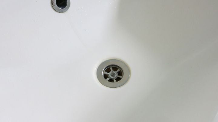 Ein strahlend wei&szlig;es Waschbecken mit einem klaren Abfluss und einem unbenutzten Wasserhahn in einem modernen Badezimmer.