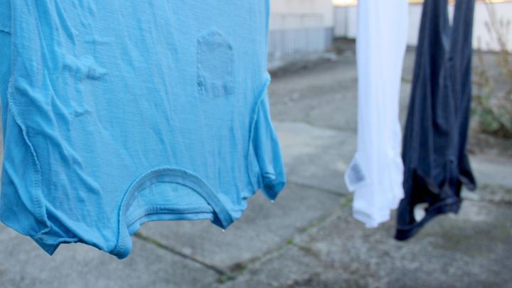 Bunte W&auml;sche h&auml;ngt im Freien an einer Leine und sieht knittrig aus, bereit, m&ouml;glicherweise durch Wind gegl&auml;ttet zu werden.