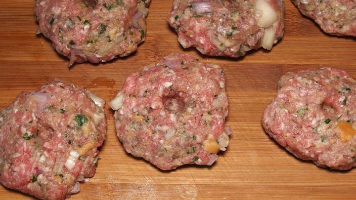 Frikadellen liegen auf einem Holzbrett, bereit zum Garen, um schnell ein leckeres Gericht zu werden.