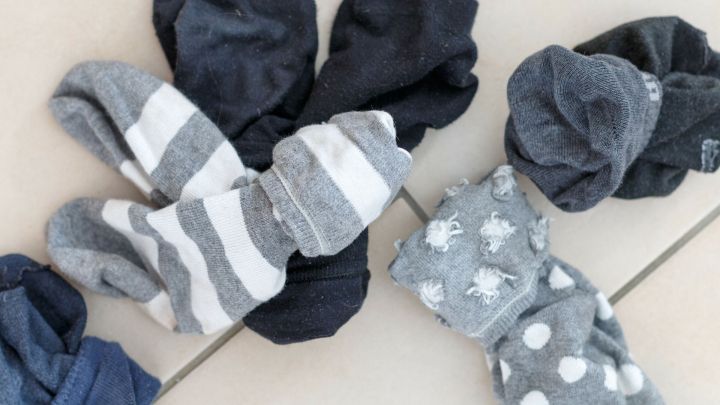 Bunte Socken liegen chaotisch auf einem sauberen Boden, w&auml;hrend sie darauf warten, gewaschen zu werden und keine Socken verloren gehen.