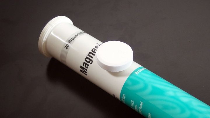 Eine Tube mit Muskelgel liegt auf einem dunklen Hintergrund, bereit zur Anwendung zur Vorbeugung von Muskelkater nach dem Sport.