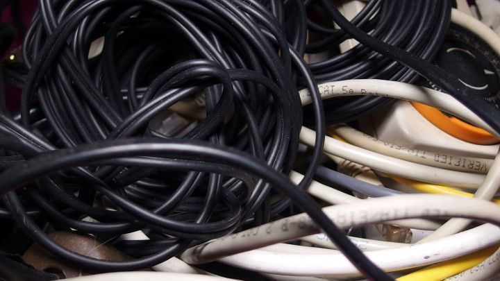 Verwirrte Kabel liegen ineinander verwoben in einem Beh&auml;lter, was ein chaotisches Bild der Ordnung zeigt.