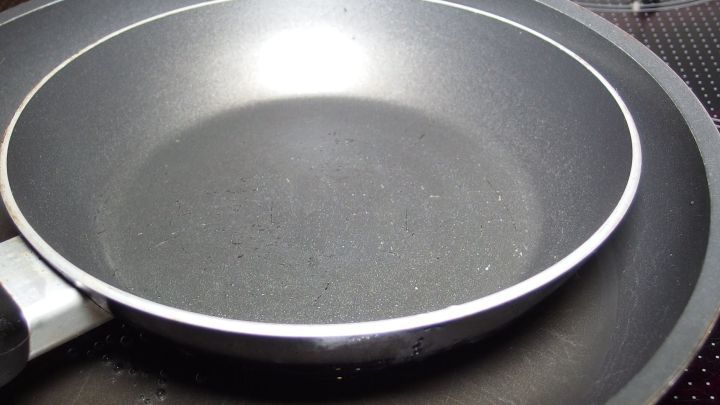 Eine Pfanne liegt sauber auf einem Kochfeld, bereit f&uuml;r die Reinigung mit Soda, um m&ouml;gliche R&uuml;ckst&auml;nde zu entfernen.