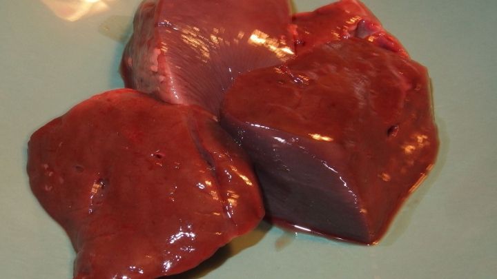 Auf einem Teller liegen mehrere frische Leberst&uuml;cke, bereit zum Mahlen im Fleischwolf f&uuml;r die Zubereitung.