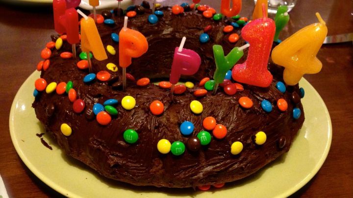 Ein saftiger Schokoladenkuchen mit bunten Streuseln und Kerzen, dekoriert f&uuml;r einen Geburtstagsfeier im Esszimmer.