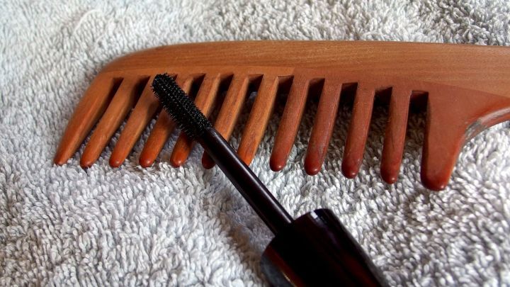 Ein Kamm und ein Applikator f&uuml;r Haaransatz kaschieren liegen auf einem Handtuch, bereit zum Verwenden f&uuml;r die Haarpflege.