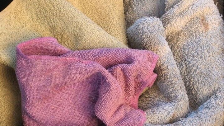 Bunte Handt&uuml;cher sind &uuml;bereinander gestapelt und bereit zum Waschen bei 30 Grad, um Energie und Wasser zu sparen.