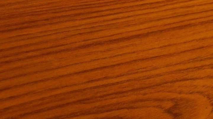 Kratzer im Mahagoniholz sind sichtbar auf der glatten Holzoberfl&auml;che, die in warmen, reichen Braunt&ouml;nen schimmert.