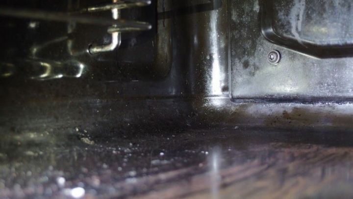 Ein schmutziger Backofenboden wird mit einem Glaskeramikfeldreiniger gereinigt, um R&uuml;ckst&auml;nde zu entfernen.