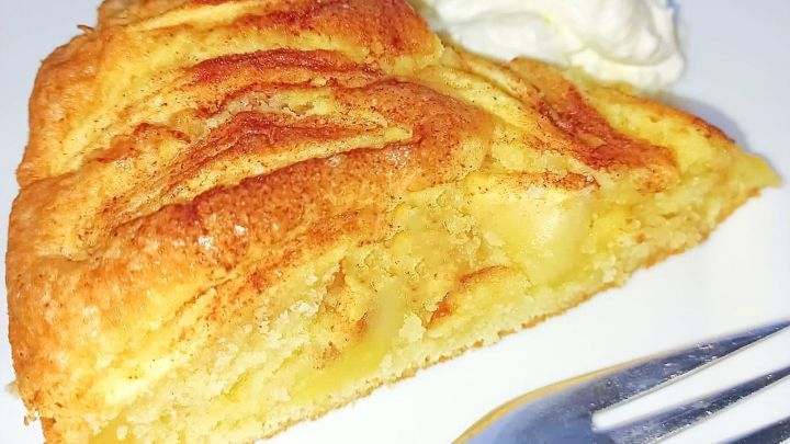 Ein St&uuml;ck Apfelkuchen liegt auf einem wei&szlig;en Teller neben einem Klecks Sahne, bereit zum Genie&szlig;en.