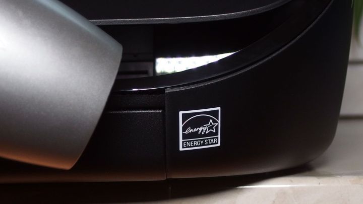 Ein F&ouml;hn entfernt einen Aufkleber mit Folienoberfl&auml;che von einer dunklen Oberfl&auml;che in einer hellen Umgebung.