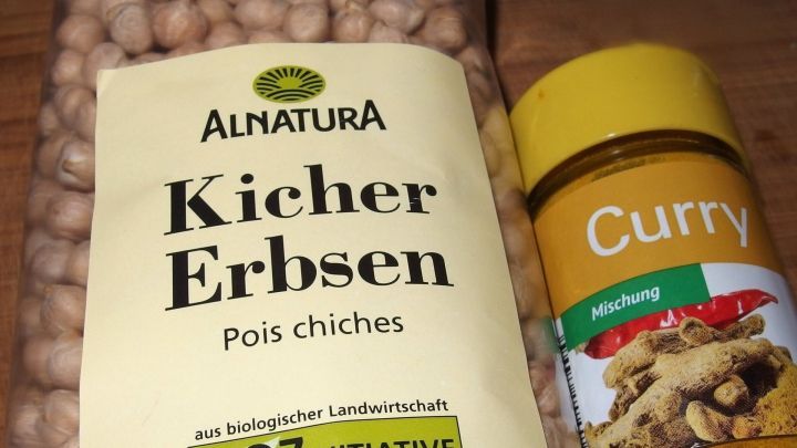 Kichererbsen und Currypulver stehen auf einem Tisch, bereit zur Zubereitung eines schnellen Kichererbsencurrys.
