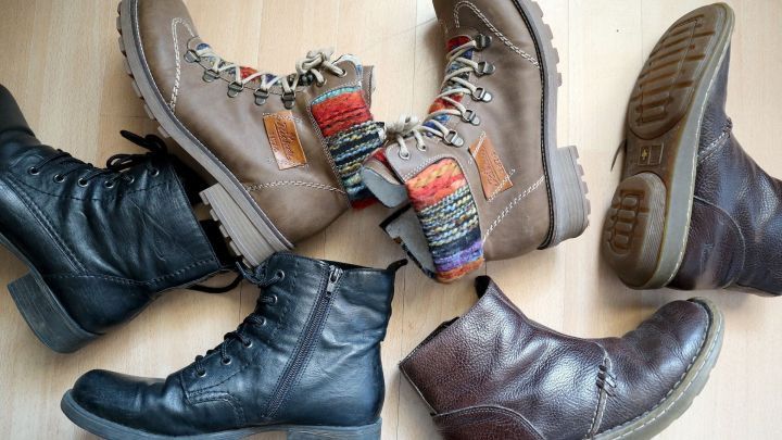 Diverse Stiefel liegen kreuz und quer auf einem hellen Boden, bereit zum Tragen in unterschiedlichen Casual-Situationen.