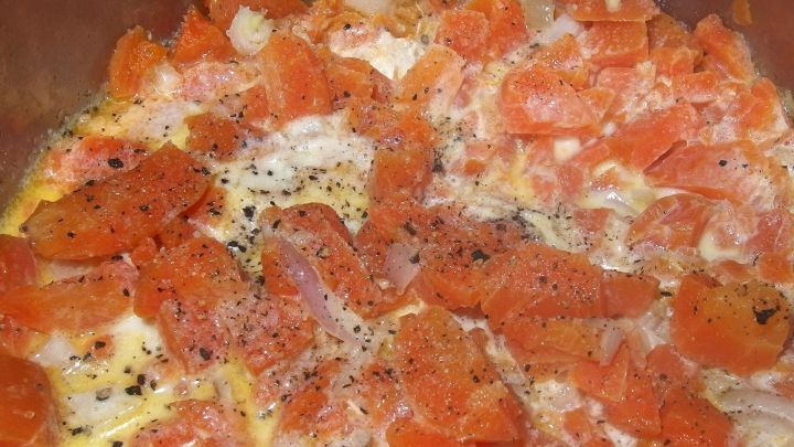 Zarte Sahnem&ouml;hrchen werden in einer Pfanne mit Tomaten und Gew&uuml;rzen angebraten, um eine k&ouml;stliche Beilage zu kreieren.