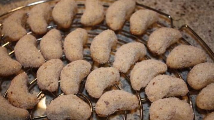 Vanillekipferl k&uuml;hlen auf einem runden Gitter ab; sie liegen auf einer Granitoberfl&auml;che.