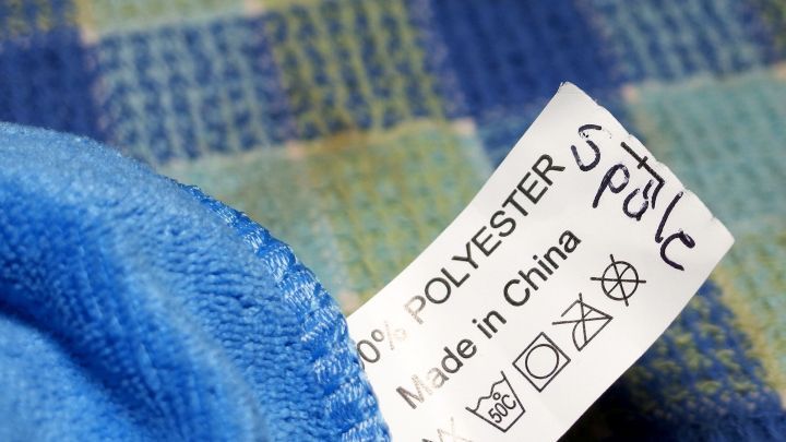 Ein Microfasertuch liegt auf einem bunten Gewebe und hat ein Etikett mit Informationen &uuml;ber das Material und die Herkunft.