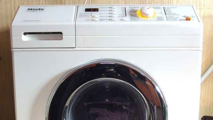 Eine Waschmaschine verarbeitet W&auml;sche im Innenraum, w&auml;hrend sie effektive Abw&auml;rme erzeugt, die genutzt werden kann.