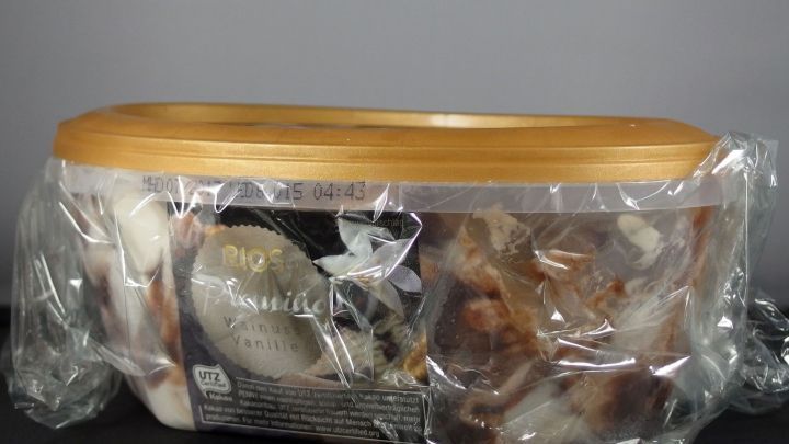 Eine Eist&uuml;te steht in einer transparenten Verpackung auf einem dunklen Tisch. Die Eiscreme bleibt weich und bildet keine Eiskristalle.