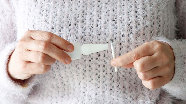 Eine Person h&auml;lt einen kleinen Nagel in einer Hand und eine Flasche Sekundenkleber in der anderen, um einen lockeren Nagel zu reparieren.