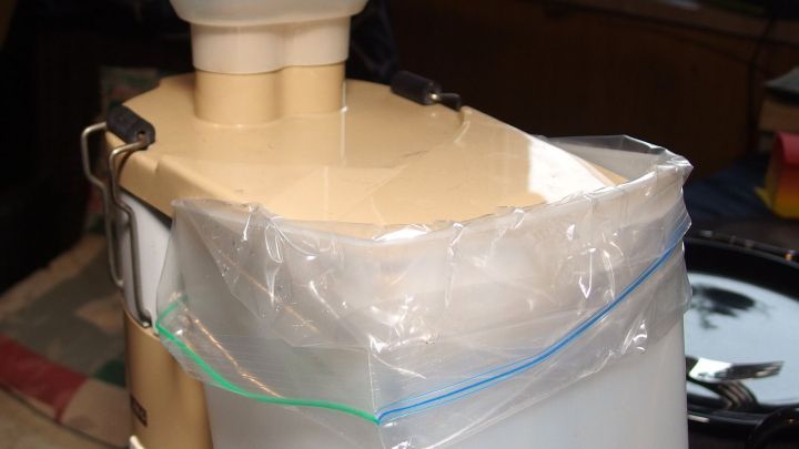 Ein Beh&auml;lter f&uuml;r Trester ist sauber verpackt und bereit zum Auffangen, in einer K&uuml;che mit unauff&auml;lligem Hintergrund.