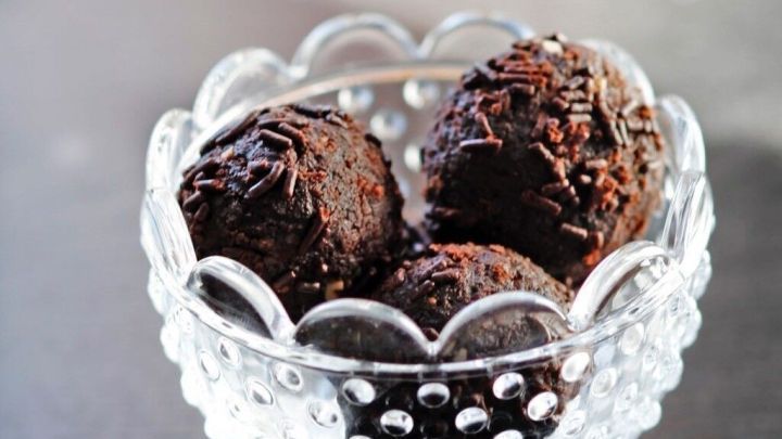 Schokoladige Tr&uuml;ffelkugeln liegen in einer eleganten Glasschale und laden zu einer k&ouml;stlichen Kaffee-Pause ein.