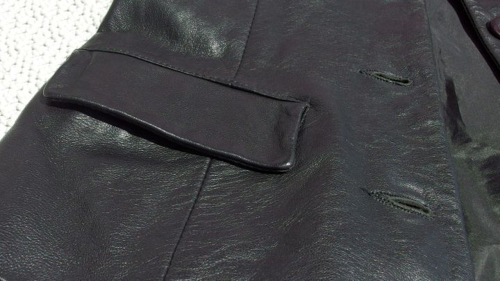 Ein schwarzes Lederst&uuml;ck liegt flach auf einem hellen Untergrund, bereit f&uuml;r die Lederpflege mit Vaseline.