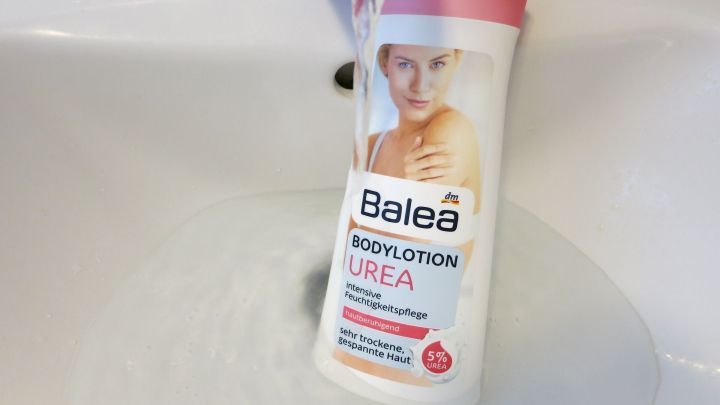 Ein Flakon mit Balea Bodylotion h&auml;ngt unter einem Wasserhahn und wird von Wasser umgeben, was eine frische Anwendung symbolisiert.