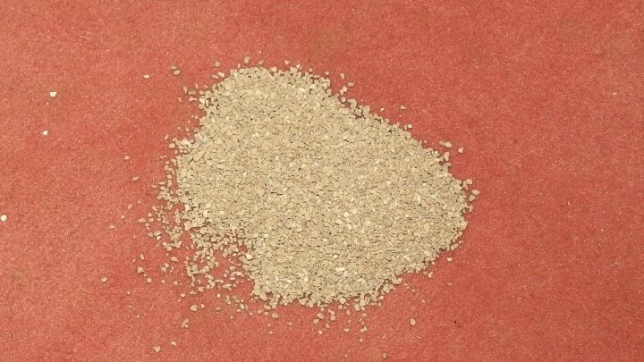 Ein Haufen Katzenstreu liegt auf einem Teppich, w&auml;hrend der Versuch l&auml;uft, Erbrochenes zu entfernen.