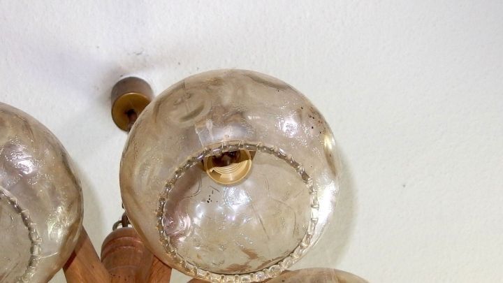 Glaslampenschirme h&auml;ngen von der Decke und sind leicht verschmutzt; eine Reinigung wird empfohlen, um ihren Glanz zu zeigen.