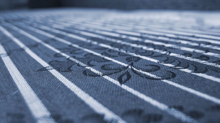 Ein gestreifter Stoff mit floralem Muster liegt flach da, ideal f&uuml;r die Reinigung von Blutflecken mit Autoinnenreiniger.