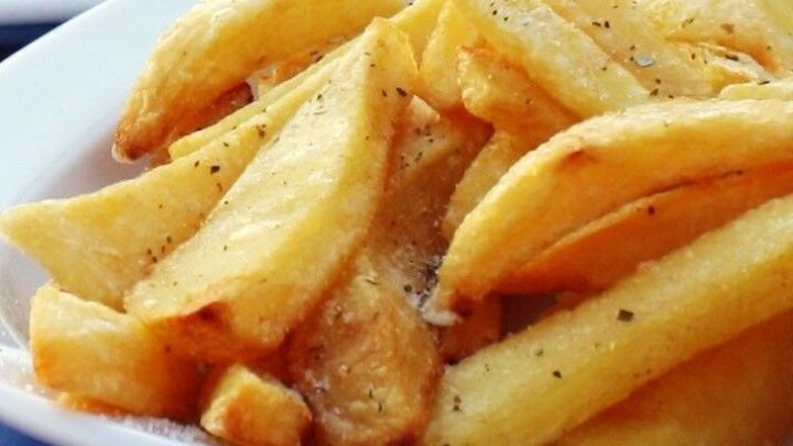 Knusprige Pommes liegen gebr&auml;unt in einer Sch&uuml;ssel, frisch serviert und appetitlich gew&uuml;rzt im Restaurant.