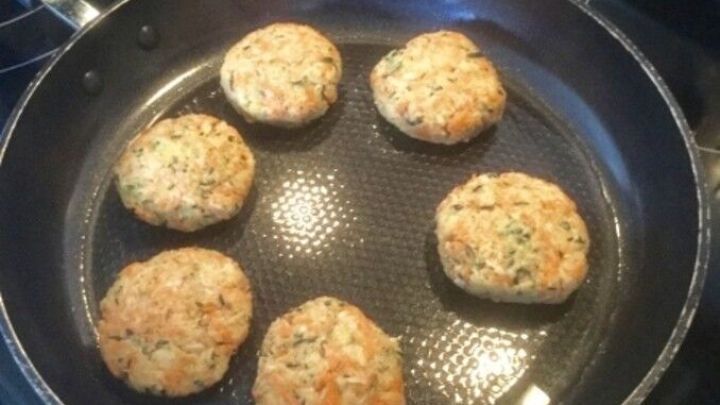 Zucchini-basisierte Bratlinge braten in einer Pfanne auf einem Herd, um eine schmackhafte Mahlzeit f&uuml;r Kinder zuzubereiten.