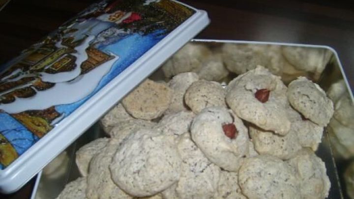 Eine Keksdose mit verschiedenen, hellen Keksen steht offen auf einem Tisch, bereit f&uuml;r die Kaffeetafel-Bewirtung.