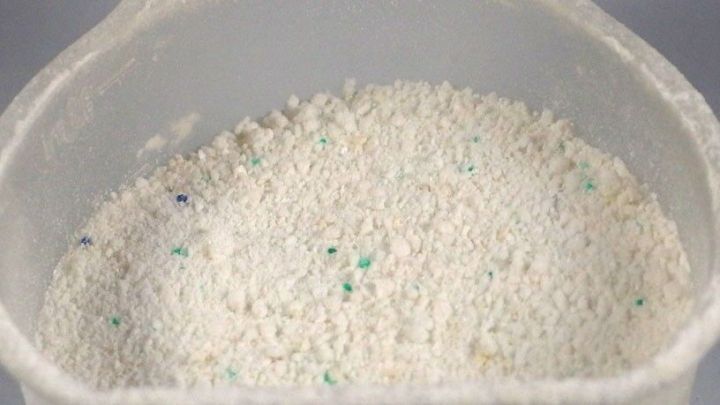 Ein Beh&auml;lter mit Waschpulver steht auf einer Oberfl&auml;che und zeigt die wei&szlig;e, granulierte Textur des Produkts.