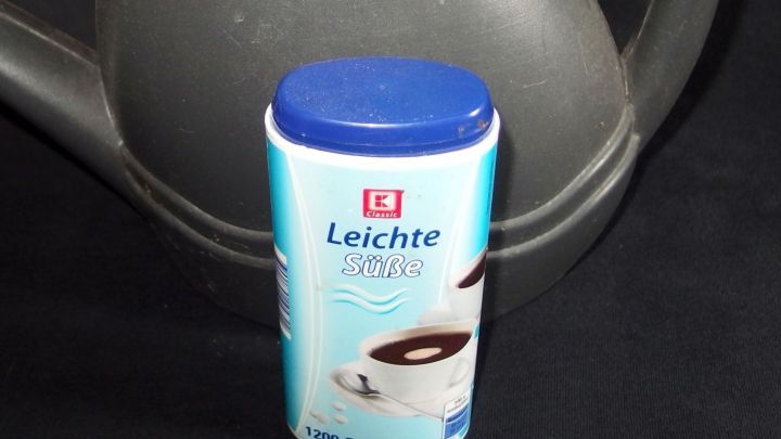 Eine D&uuml;ngemitteldose steht neben einer Gie&szlig;kanne und zeigt die Anwendung f&uuml;r preisg&uuml;nstiges D&uuml;ngen von Pflanzen.