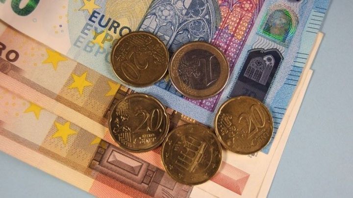 M&uuml;nzen und Geldscheine liegen auf einem Tisch, symbolisieren Sparen und m&ouml;gliche Gewinne im finanziellen Kontext.