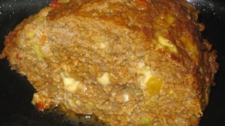 Ein saftiger Hackbraten wird appetitlich angerichtet und pr&auml;sentiert sich auf einem dunklen Teller, ideal f&uuml;r die Mikrowelle.