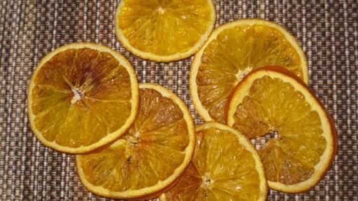 D&uuml;nne, getrocknete Orangenscheiben liegen auf einem gewebten Tisch. Ideal f&uuml;r die Weihnachtsbastelei und Dekoration.