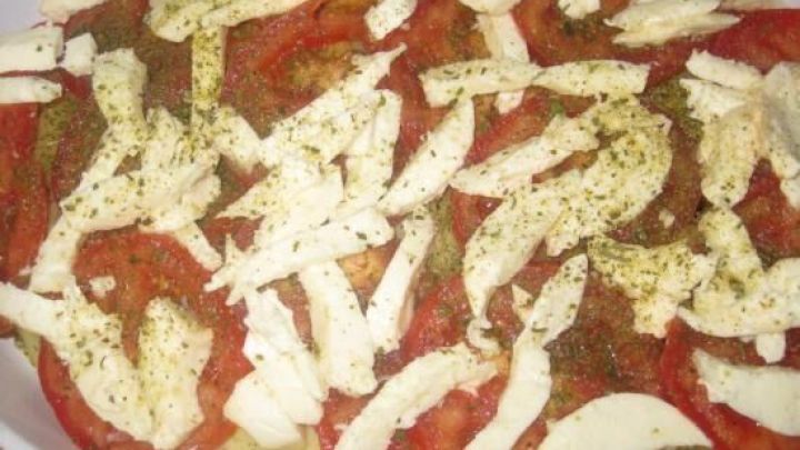 Kartoffelgratin mit Schichten aus Kartoffeln, frischen Tomaten und K&auml;se, gew&uuml;rzt und bereit zum Backen.