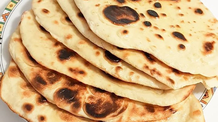 Ein Stapel frisch gebratener Hefefreier Fladenbrote liegt auf einem dekorativen Teller, bereit zum Servieren.